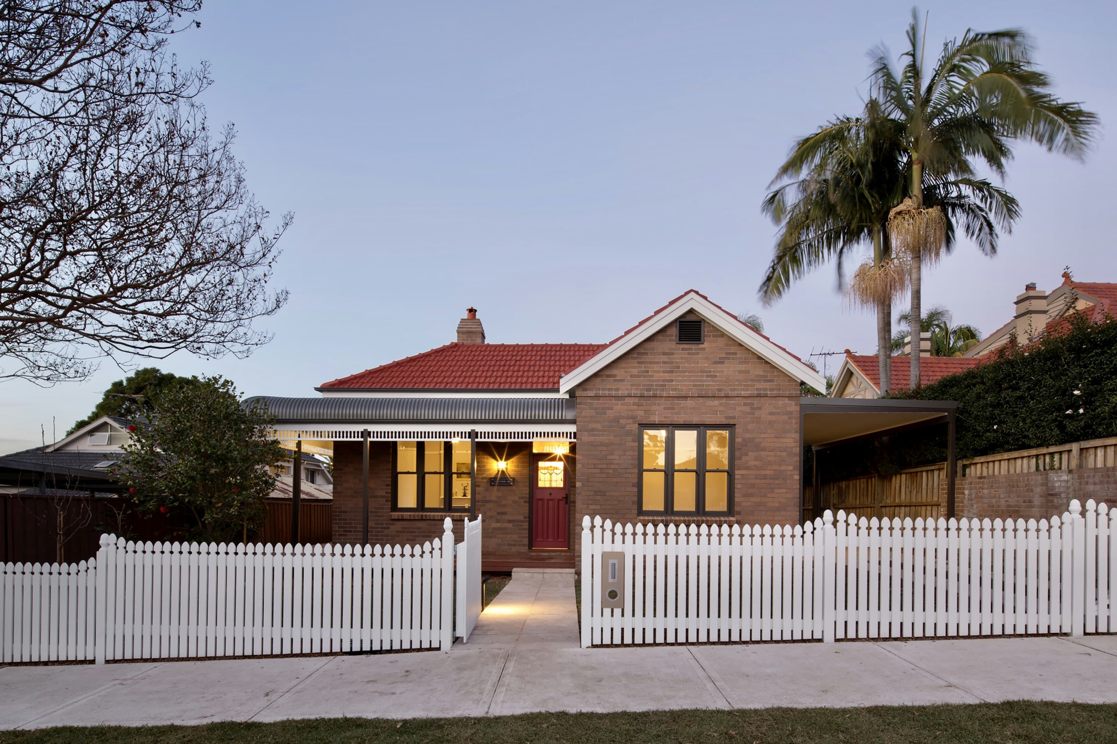 Federation brick house at dusk with warm interior lighting